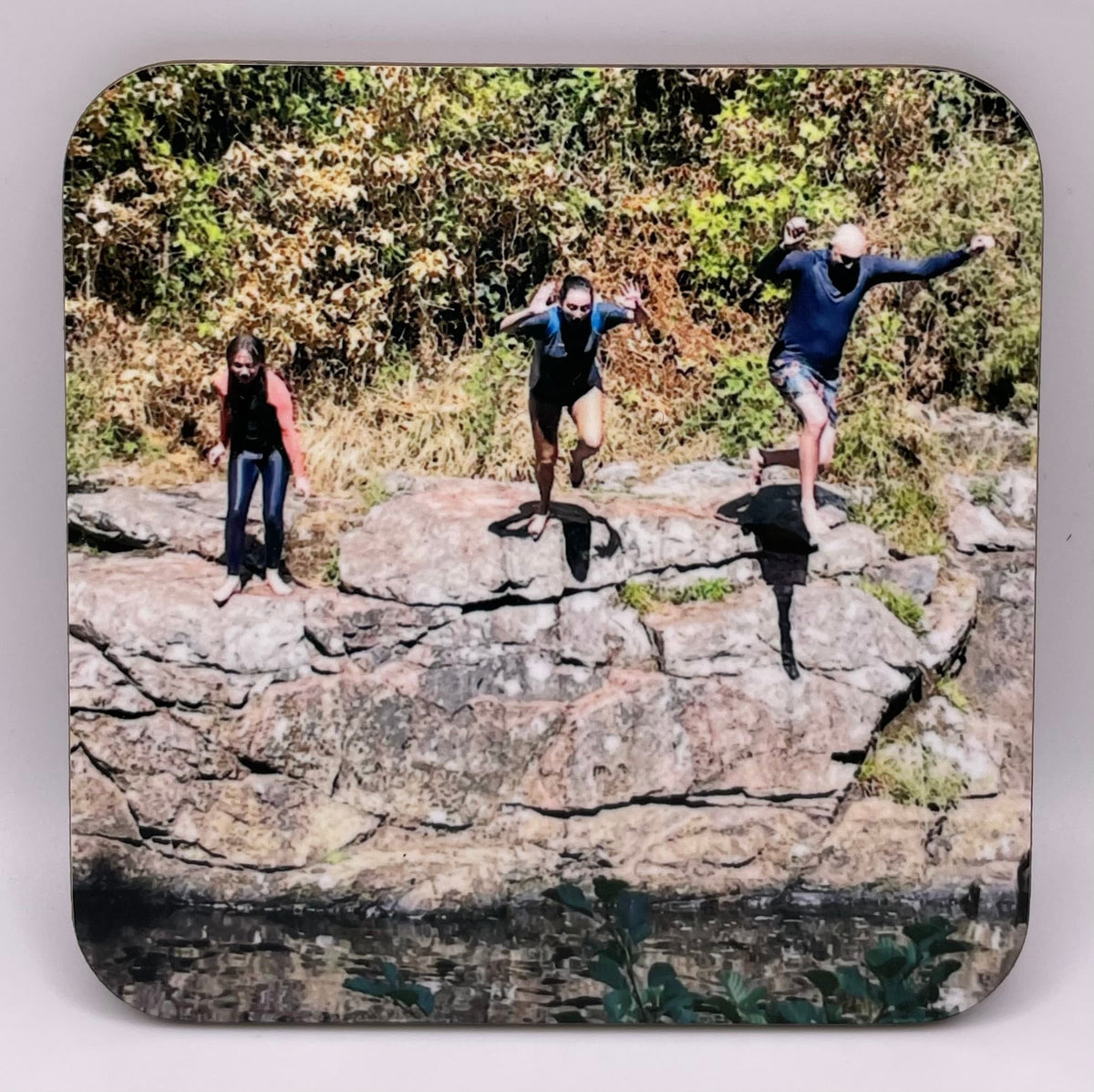 Custom coaster photo example showing 3 people leaping in to a river off the rocks