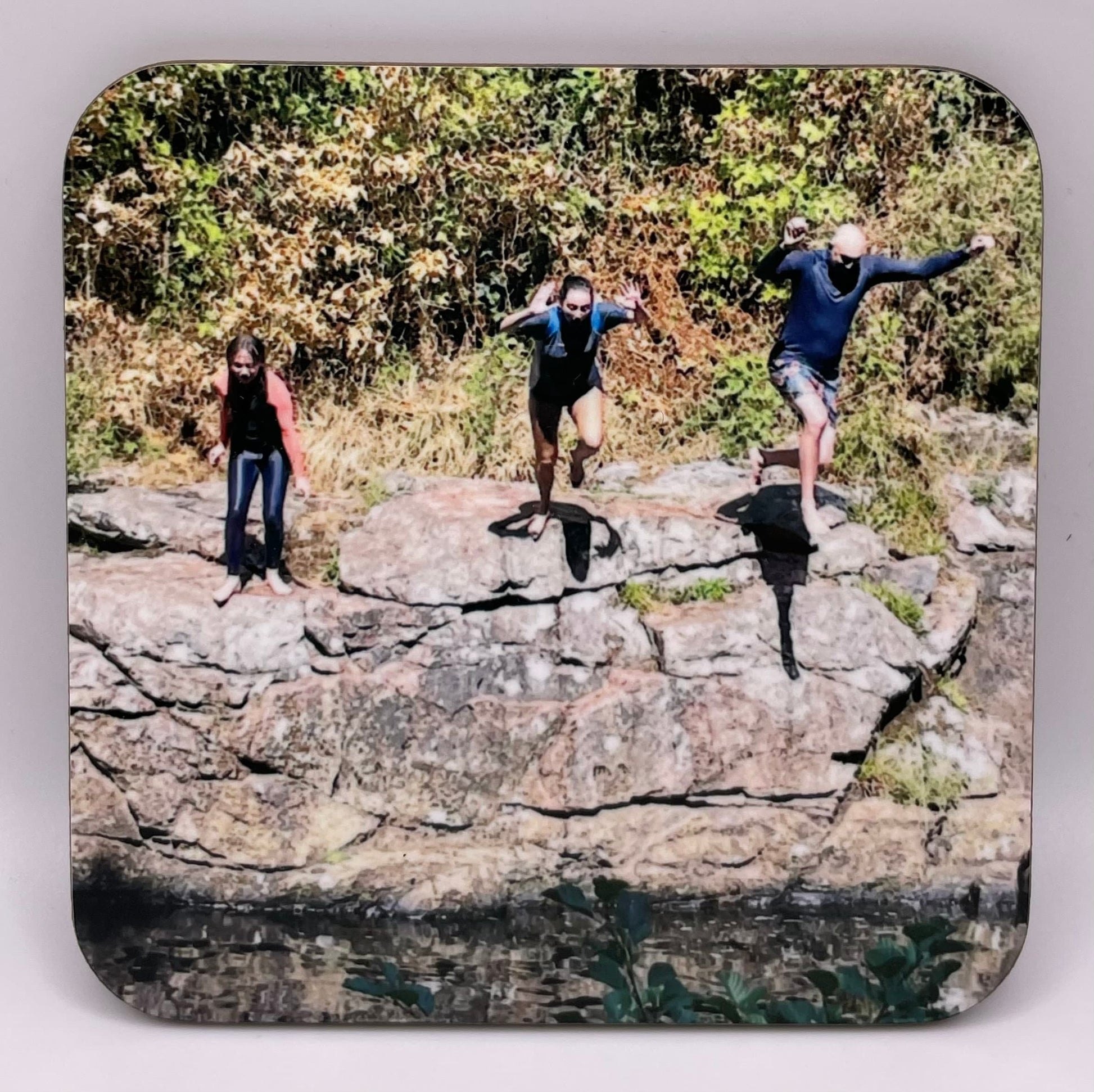 Custom coaster photo example showing 3 people leaping in to a river off the rocks